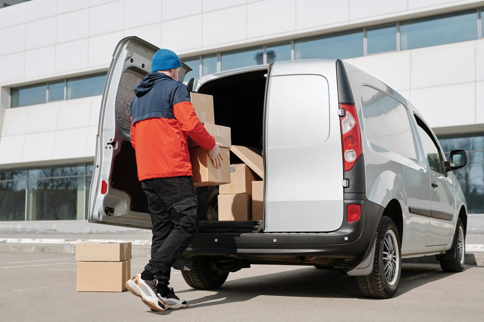 Courier loading packages into delivery van for local delivery service