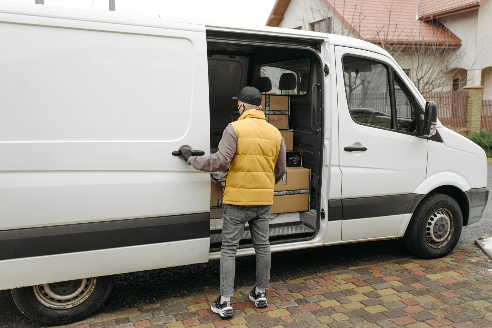 Delivery driver loading packages into courier van
